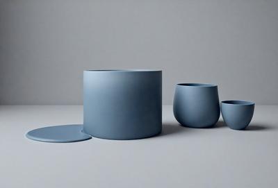 The primary subject of the image is a blue vase, which is placed on a white surface. The vase is accompanied by two other blue vases, creating a visually appealing arrangement. The setting appears to be a studio or a workspace, as the vases are displayed in a neat and organized manner. The visual style of the image is a combination of photo and digital art, giving it a modern and contemporary feel. The dominant colors in the image are blue and white, creating a calm and serene atmosphere.