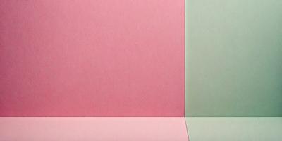 The primary subject of the image is a pink and green piece of paper. The setting is a table, and the visual style is a close-up of the paper. The colors and mood of the image are predominantly pink and green, creating a warm and inviting atmosphere.