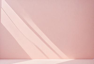 The primary subject of the image is a wall with a pink background. The setting is a room with a white floor. The visual style is a photo, and the colors and mood are predominantly pink and warm.