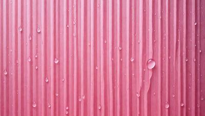 The primary subject of the image is a pink surface with water droplets on it. The setting is a pink wall, and the visual style is a close-up of the pink wall with water droplets. The colors and mood of the image are predominantly pink, creating a warm and inviting atmosphere.