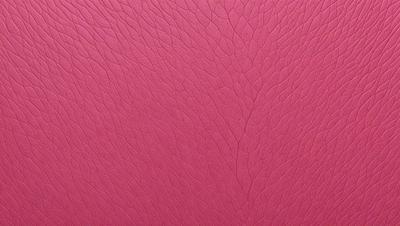 The primary subject of the image is a close-up of a pink leather surface. The setting is a room with a pink background. The visual style is a photo, and the colors and mood are predominantly pink, creating a warm and inviting atmosphere.
