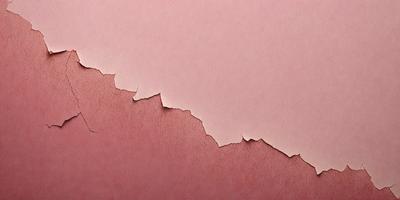 The primary subject of the image is a piece of pink paper with a large crack in it. The paper appears to be peeling or damaged, giving it a worn and aged appearance. The setting is a pink background, which complements the color of the paper. The visual style of the image is a close-up of the paper, highlighting the crack and the pink color. The colors and mood of the image are predominantly pink, giving it a warm and inviting atmosphere.