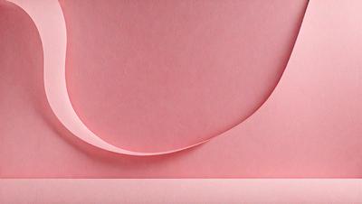 The primary subject of the image is a pink sheet of paper with a curved edge. The setting is a room with a pink background. The visual style is a close-up of the paper, showcasing its texture and color. The colors and mood of the image are predominantly pink, creating a warm and inviting atmosphere.