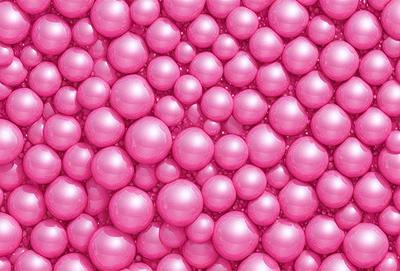 The primary subject of the image is a large pink surface with numerous small pink balls or bubbles scattered across it. The setting appears to be a pink background, and the visual style is a close-up of the pink surface with the bubbles. The colors and mood of the image are predominantly pink, creating a warm and inviting atmosphere.