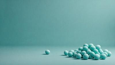 The primary subject of the image is a group of blue balls, which are the main objects in the scene. The setting is a blue background, which creates a visually appealing contrast with the blue balls. The visual style of the image is a photo, capturing the details and colors of the blue balls. The overall atmosphere of the image is calm and serene, with the blue balls sitting on a blue surface.