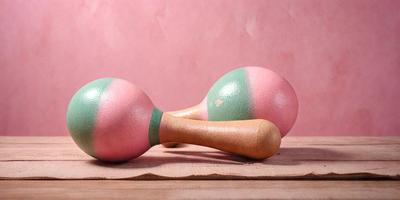 The primary subject of the image is a pair of wooden dumbbells, which are placed on a wooden table. The setting is a pink wall, which serves as the background for the scene. The visual style of the image is a photo, capturing the wooden dumbbells in their natural environment. The colors and mood of the image are predominantly pink, creating a warm and inviting atmosphere.