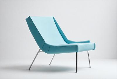 The primary subject of the image is a blue chair with a metal frame. The chair is positioned on a white surface, which serves as the setting or background. The visual style of the image is a photo, capturing the chair's unique design and color. The dominant colors in the image are blue and white, creating a clean and modern atmosphere.