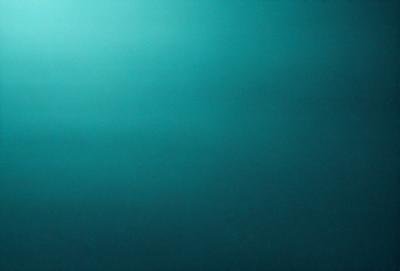 The primary subject of the image is a large body of water, which appears to be a deep blue ocean. The setting is a vast expanse of water, with no visible land or other objects in the background. The visual style of the image is a close-up of the water, showcasing its depth and beauty. The colors and mood of the image are predominantly blue, creating a serene and tranquil atmosphere.