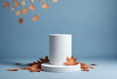 The primary subject of the image is a white, round, and flat object, which appears to be a vase or a base for a vase. The setting is a blue background, which creates a contrasting and visually appealing environment. The visual style of the image is a photo, capturing the details and colors of the white object and the surrounding leaves. The colors and mood of the image are predominantly blue and white, giving it a clean and serene atmosphere.