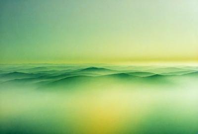The primary subject of the image is a mountain range, which is depicted in a green and yellow hue. The setting is a vast, open landscape with a sky background. The visual style is a combination of photo and digital art, creating a vibrant and dynamic scene. The colors and mood convey a sense of tranquility and natural beauty, as the mountains stretch across the horizon.