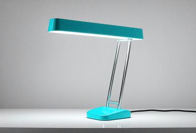 The primary subject of the image is a blue desk lamp with a light on. The lamp is placed on a white surface, which serves as the setting or background. The visual style of the image is a photo, capturing the lamp's light and color. The dominant colors in the image are blue and white, creating a calm and soothing atmosphere.