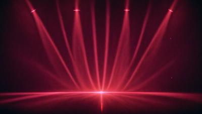 The primary subject of the image is a red light, which appears to be a spotlight or a light source. The setting is a dark room, and the visual style is a close-up of the red light. The colors and mood of the image are predominantly red, creating a bold and striking atmosphere.
