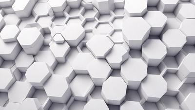 The primary subject of the image is a white wall with a pattern of white hexagons. The setting is a white room, and the visual style is a close-up of the wall. The dominant colors are white, and the overall atmosphere is clean and minimalistic.