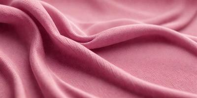 The primary subject of the image is a piece of pink fabric. The setting is a room with a pink background. The visual style is a close-up of the fabric, showcasing its texture and color. The colors and mood of the image are predominantly pink, creating a warm and inviting atmosphere.