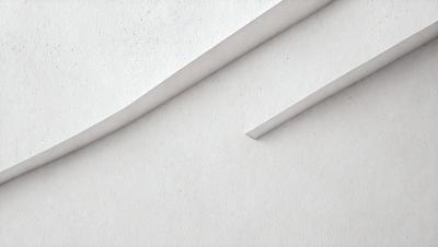 The primary subject of the image is a white paper with a blue line on it. The paper is folded in half, creating a crease. The setting is a white background, and the visual style appears to be a photo. The colors and mood of the image are predominantly white and blue, giving it a clean and calm atmosphere.
