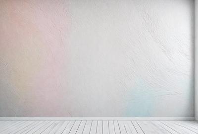 The primary subject of the image is a white wall with a colorful, textured design. The setting is a room with a wooden floor. The visual style is a combination of photo and digital art, creating a unique and artistic appearance. The dominant colors are white and various shades of pink, blue, and green, giving the wall a vibrant and lively atmosphere.