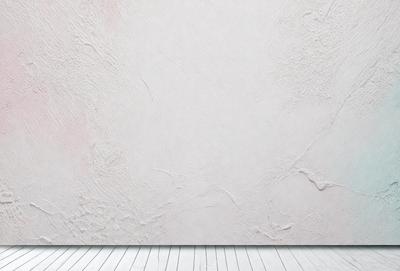 The primary subject of the image is a white wall with a white baseboard. The setting is a room with a white floor. The visual style is a photo, and the colors and mood are predominantly white, giving the image a clean and minimalist appearance.
