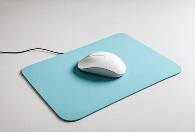 The primary subject of the image is a white computer mouse. The mouse is placed on a blue mouse pad, which is sitting on a white surface. The visual style of the image is a photo, and the colors and mood are predominantly blue and calm.