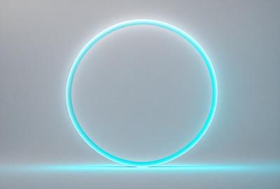The primary subject of the image is a large, illuminated, blue circle. The circle is the main object, scene, or focus of the image. The setting is a white wall, which serves as the backdrop for the circle. The visual style of the image is a combination of photo and digital art, as it appears to be a photograph of a digital art piece. The colors and mood of the image are predominantly blue, creating a calm and serene atmosphere.