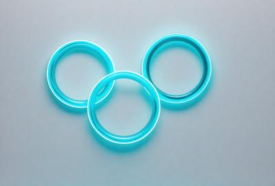 The primary subject of the image is a pair of blue rings, which are placed on a white surface. The setting is a table, and the visual style is a photo. The dominant colors are blue and white, creating a clean and modern atmosphere.