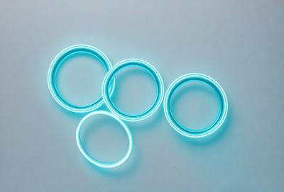 The primary subject of the image is a group of five blue rings. They are arranged in a circle, with each ring being slightly larger than the one before it. The setting is a white background, which provides a clean and uncluttered environment for the rings to stand out. The visual style is a close-up of the rings, allowing for a detailed view of their unique shapes and colors. The dominant colors in the image are blue, which gives the scene a calm and soothing atmosphere.