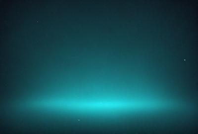 The primary subject of the image is a blue sky with a few stars visible. The setting is a dark, starry night, creating a dramatic and serene atmosphere. The visual style is a photo, capturing the beauty of the night sky. The colors and mood are predominantly dark and moody, with the blue sky and stars providing a sense of depth and tranquility.