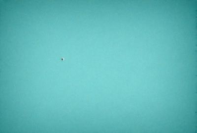 The primary subject of the image is a small dot, which appears to be a single point of light. The setting is a vast, empty blue sky, with no other objects or distractions visible. The visual style is a simple, minimalist representation of the dot against the backdrop of the sky. The colors and mood of the image are predominantly blue, creating a sense of calmness and tranquility.