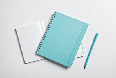The primary subject of the image is a blue notebook with a pen placed on top of it. The setting is a white table, and the visual style is a photo. The colors and mood of the image are predominantly blue, creating a calm and organized atmosphere.