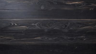 The primary subject of the image is a wooden floor with a black color. The setting is a room with a black wall, and the visual style is a close-up of the wooden floor. The colors and mood of the image are dark and moody, creating a sense of depth and richness.