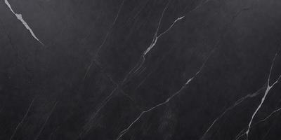 The primary subject of the image is a close-up of a black marble countertop. The setting is a kitchen, with the countertop being the main focus of the scene. The visual style is a photo, capturing the intricate details of the marble surface. The colors and mood of the image are predominantly dark, with the black marble providing a striking contrast against the dark background.