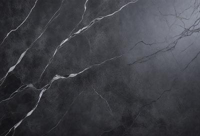 The primary subject of the image is a black marble countertop. The setting is a dark room, and the visual style is a close-up of the marble countertop. The countertop appears to be a dark grey color, giving it a sophisticated and elegant appearance.