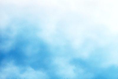 The primary subject of the image is a cloudy blue sky. The setting is a vast expanse of the sky, with no visible land or other objects. The visual style is a natural, outdoor scene. The colors and mood are predominantly blue, with a slightly overcast atmosphere.