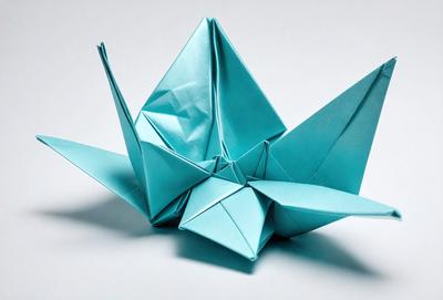 The primary subject of the image is a blue origami crane. The setting is a white background, and the visual style is a photo. The colors and mood of the image are predominantly blue, creating a calm and serene atmosphere.