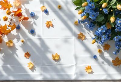 The primary subject of the image is a white tablecloth with yellow and blue flowers scattered across it. The tablecloth is placed on a table, and the flowers are arranged in a visually appealing manner. The setting appears to be an outdoor event or gathering, as the flowers are placed on the table outside. The visual style of the image is a combination of real flowers and a white tablecloth, creating a natural and inviting atmosphere. The colors and mood of the image are predominantly warm and cheerful