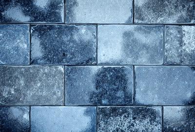 The primary subject of the image is a close-up of a black and white brick wall. The setting is a brick walkway, and the visual style is a photo. The dominant colors are black and white, creating a classic and timeless atmosphere.