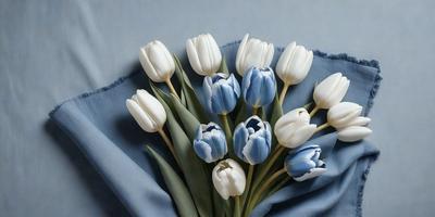The primary subject of the image is a bouquet of blue and white tulips. The setting is a blue cloth, which serves as the background. The visual style is a painting, showcasing the vibrant colors and details of the flowers. The overall atmosphere is serene and elegant, with the blue and white tulips creating a harmonious and visually pleasing composition.