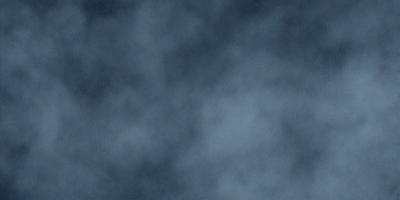 The primary subject of the image is a cloudy sky. The setting is a dark, cloudy background, which creates a moody atmosphere. The visual style is a photo, capturing the beauty of the cloudy sky. The colors are predominantly dark and gray, with some variations in the cloud formations.