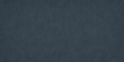 The primary subject of the image is a large, dark blue surface. The setting is a dark, empty room with no visible objects or people. The visual style is a close-up of the blue surface, which appears to be a fabric or a wall. The colors and mood of the image are predominantly dark and moody, with the blue surface being the main focus of the image.