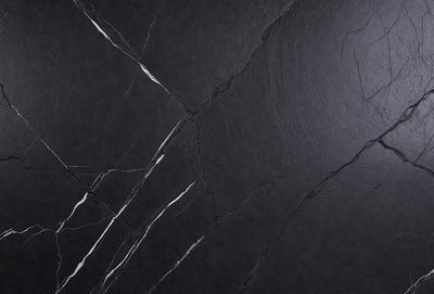 The primary subject of the image is a black marble countertop. The setting is a kitchen, with the countertop being the main focus of the scene. The visual style is a close-up of the marble countertop, showcasing its texture and details. The colors and mood of the image are dark and moody, with the black marble countertop being the dominant color.