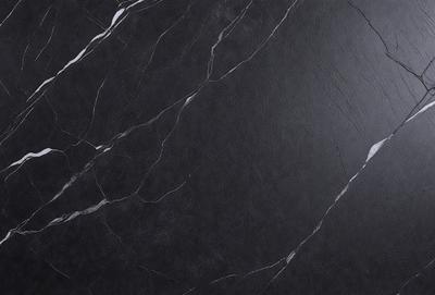 The primary subject of the image is a black marble countertop. The setting is a kitchen, with the countertop being the main focus of the scene. The visual style is a close-up of the marble countertop, showcasing its texture and details. The colors and mood of the image are predominantly dark, with the black marble countertop being the main source of contrast and visual interest.