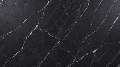 The primary subject of the image is a black marble countertop. The setting is a kitchen, with the countertop being the main focus of the scene. The visual style is a close-up of the marble countertop, showcasing its texture and pattern. The colors and mood of the image are predominantly dark, with the black marble countertop being the main source of contrast.