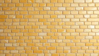 The primary subject of the image is a yellow brick wall. The setting is a room with a yellow brick wall as the main focus. The visual style is a photo, capturing the yellow brick wall in detail. The colors and mood of the image are predominantly yellow, creating a warm and inviting atmosphere.