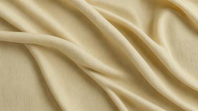 The primary subject of the image is a piece of fabric, which is the main object, scene, or focus of the image. The setting/background consists of a yellow surface, which is the color of the fabric. The visual style of the image is a photo, as it is a close-up of the fabric. The colors and mood of the image are predominantly yellow, giving it a warm and inviting atmosphere.