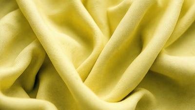 The primary subject of the image is a yellow fabric, which is the main object, scene, or focus of the image. The setting or background of the image is a yellow cloth, and the visual style is a photo. The dominant colors and overall atmosphere of the image are yellow and warm, creating a sense of brightness and freshness.