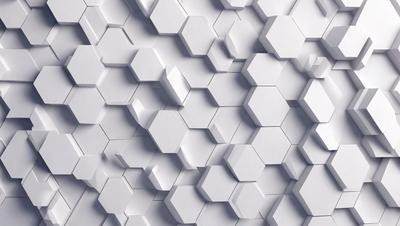 The primary subject of the image is a white wall with a pattern of hexagonal shapes. The setting is a white wall, and the visual style is a close-up of the wall. The dominant colors are white, and the overall atmosphere is clean and minimalistic.