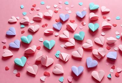 The primary subject of the image is a large number of paper hearts arranged on a pink surface. The hearts come in various shapes and sizes, creating a visually appealing and colorful display. The setting appears to be a creative and playful environment, possibly for a craft project or a decorative purpose. The visual style of the image is a combination of digital art and illustration, as the paper hearts are carefully arranged and the overall composition is well-executed. The colors and mood of the image are predominantly p