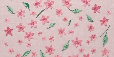 The primary subject of the image is a pattern of pink flowers, which are the main objects in the scene. The setting is a pink background, which creates a warm and inviting atmosphere. The visual style is a combination of digital art and illustration, as the flowers are depicted in a detailed and artistic manner. The colors and mood of the image are predominantly pink, which adds a sense of freshness and femininity to the scene.