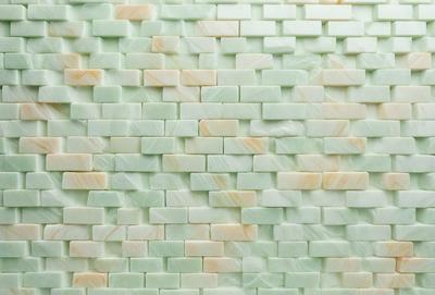 The primary subject of the image is a wall made of marble tiles. The setting is a room with a green marble wall, which serves as the background. The visual style is a close-up of the marble wall, showcasing its texture and pattern. The colors and mood of the image are predominantly green, giving the wall a natural and serene appearance.