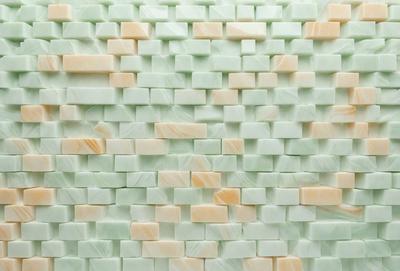 The primary subject of the image is a wall made of white tiles. The setting is a room with a green wall, and the visual style is a patterned wall. The dominant colors are white and green, creating a clean and fresh atmosphere.