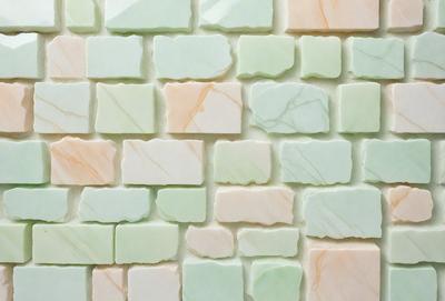 The primary subject of the image is a wall made of marble tiles. The setting is a room with a white wall, and the visual style is a photo. The colors and mood of the image are predominantly white, giving it a clean and elegant appearance.